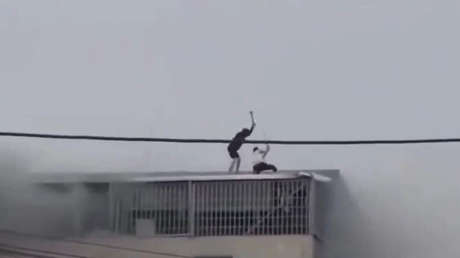 VIDEO: Hombres rescatan a siete personas de un incendio rompiendo un techo a mazazos