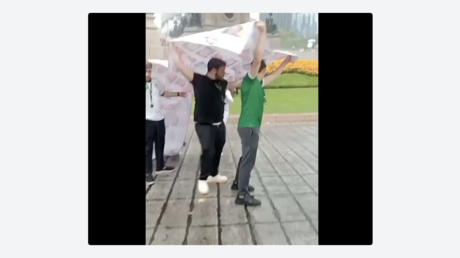 VIDEO: Aficionados se tapan de la lluvia con lona con rostros de desaparecidos en México